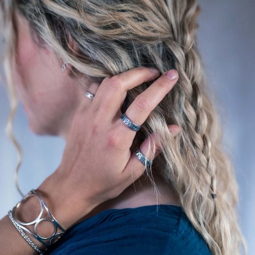A woman wearing An oxidized silver ring with a raw, oxidized texture