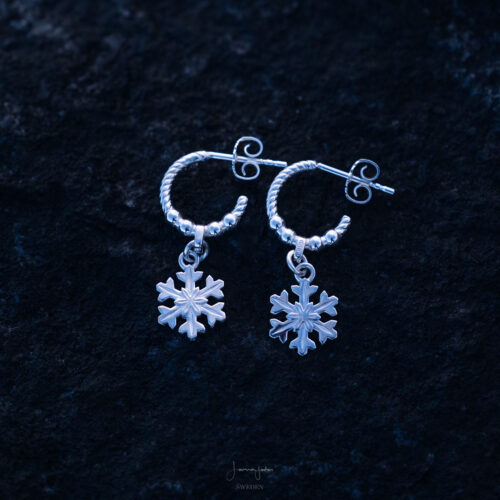Handcrafted sterling silver snowflake earrings with delicate hoop design.