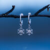 Handcrafted sterling silver snowflake earrings with delicate hoop design.