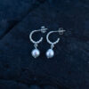 Handcrafted sterling silver pearl earrings with genuine freshwater pearls against a dark background