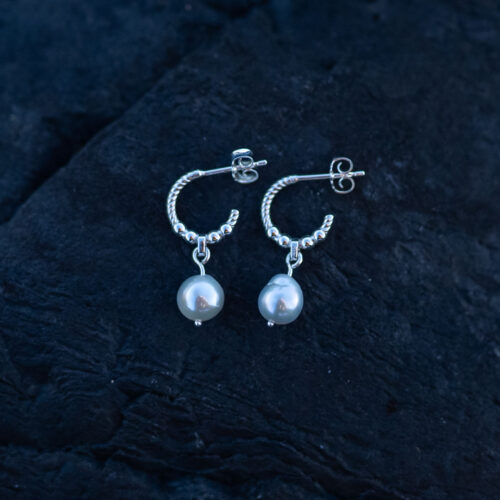 Handcrafted sterling silver pearl earrings with genuine freshwater pearls against a dark background