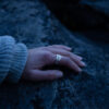 A hand wearing a Sterling silver Goddess Ring with an elegant pointed silhouette, intricate engraved details, and a hidden butterfly motif