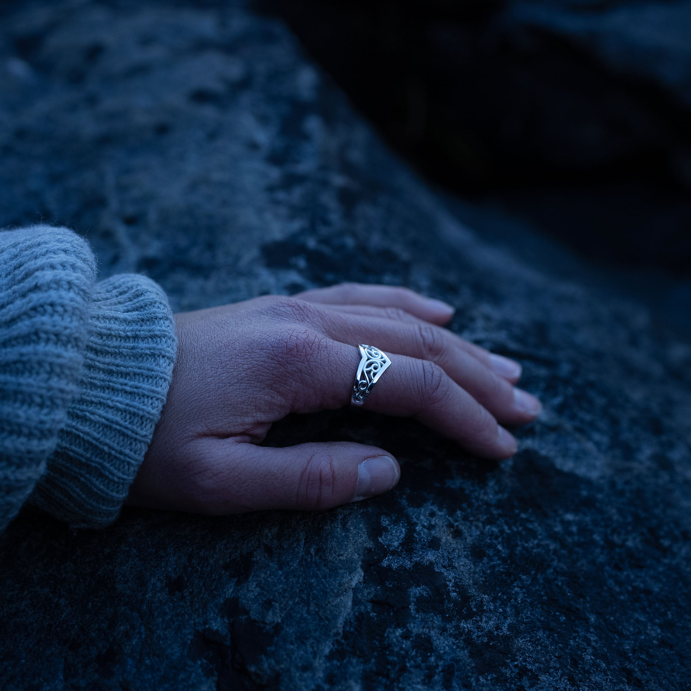A hand wearing a Sterling silver Goddess Ring with an elegant pointed silhouette, intricate engraved details, and a hidden butterfly motif