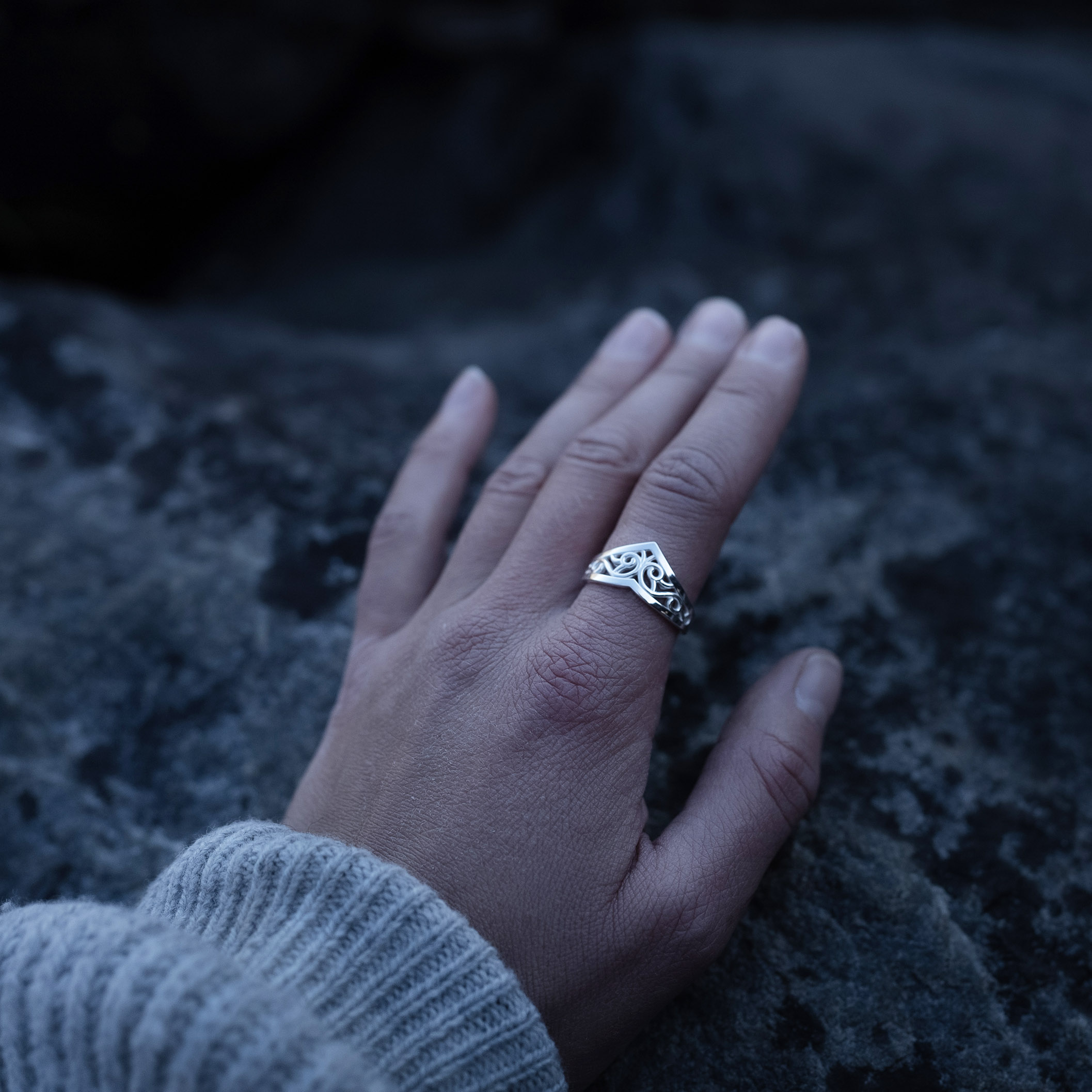 A hand wearing a Sterling silver Goddess Ring with an elegant pointed silhouette, intricate engraved details, and a hidden butterfly motif