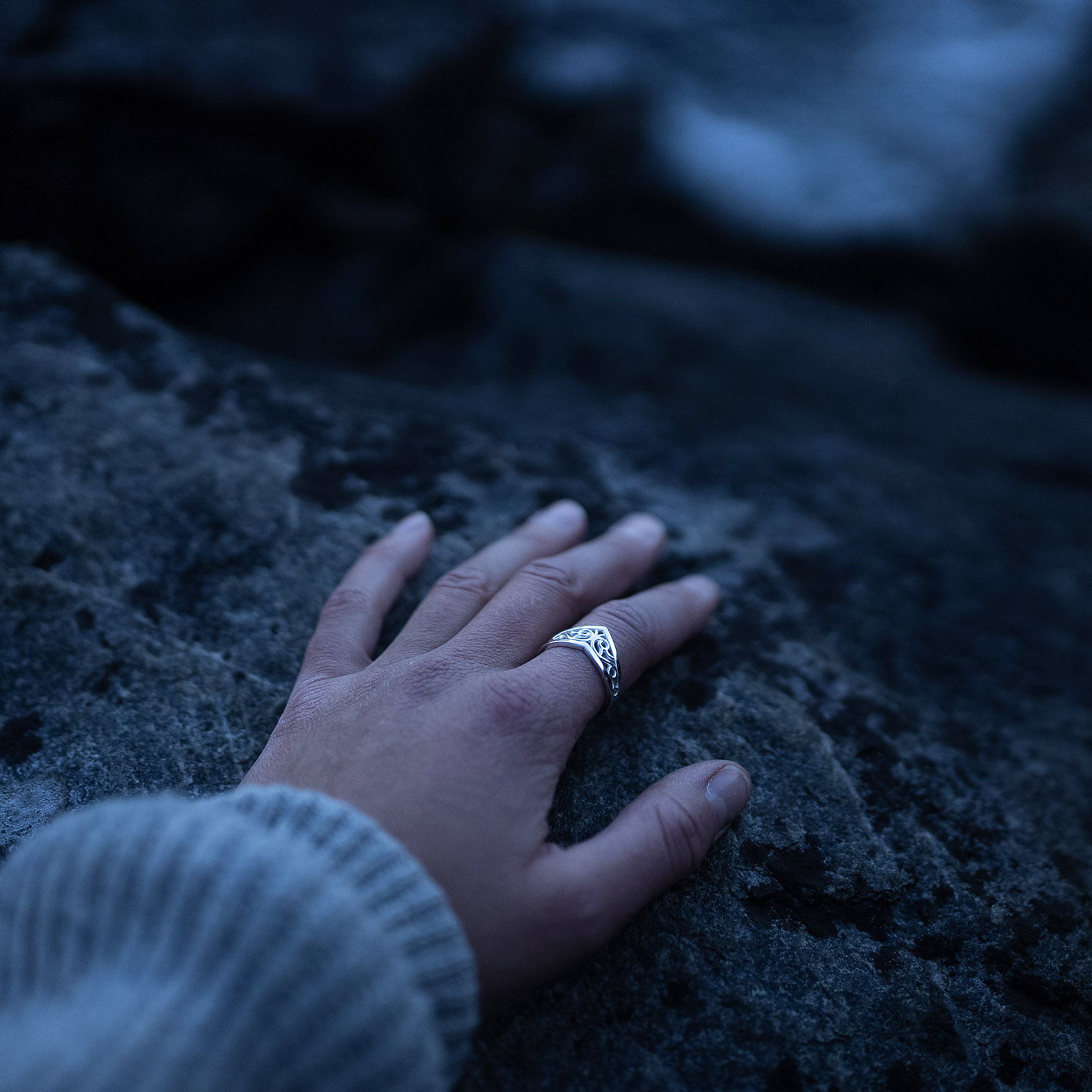 A hand wearing a Sterling silver Goddess Ring with an elegant pointed silhouette, intricate engraved details, and a hidden butterfly motif