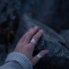 A hand wearing a Sterling silver Goddess Ring with an elegant pointed silhouette, intricate engraved details, and a hidden butterfly motif symbolizing transformation.