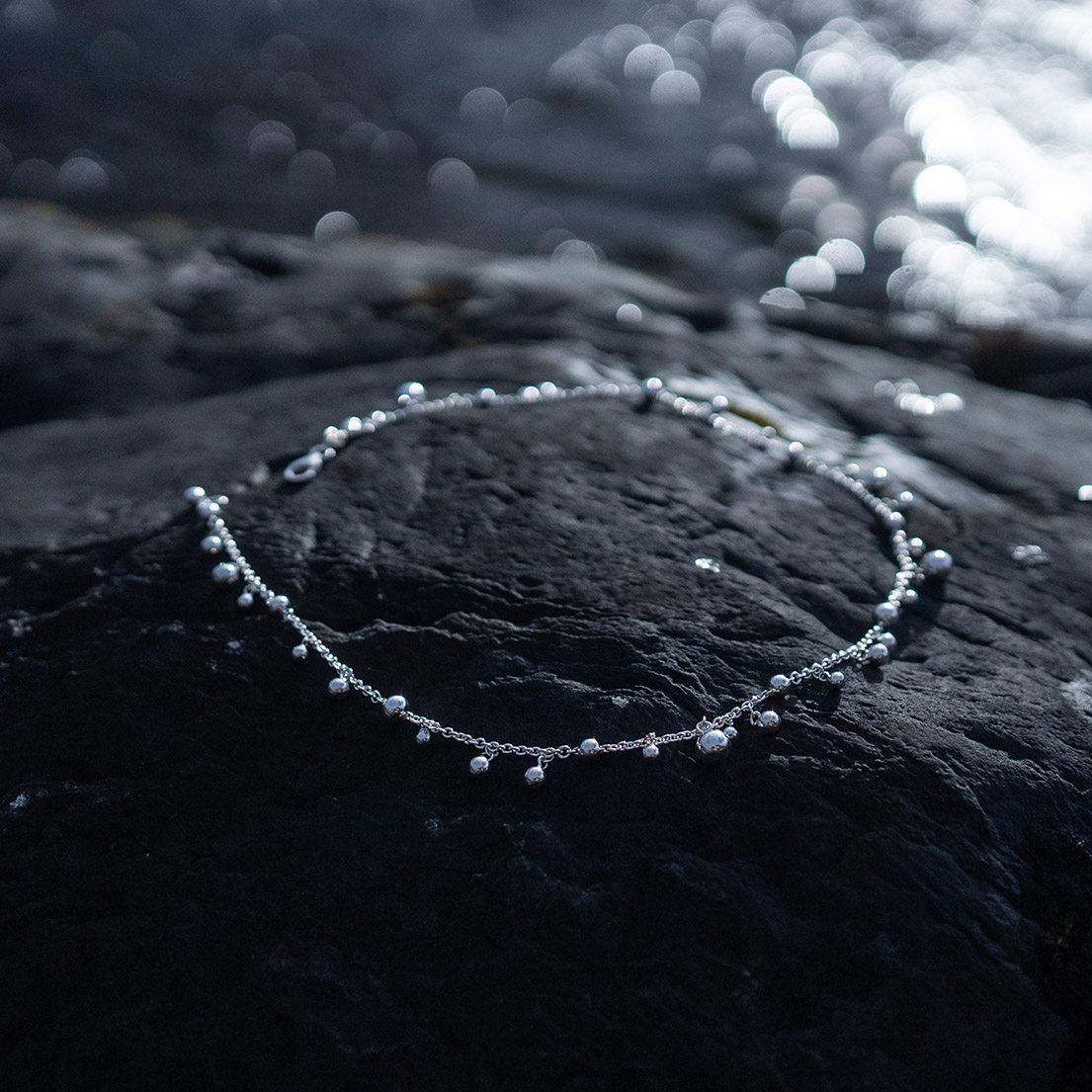Skir Necklace, a sterling silver bead necklace with polished silver beads in varying sizes on a delicate 925 sterling silver chain.