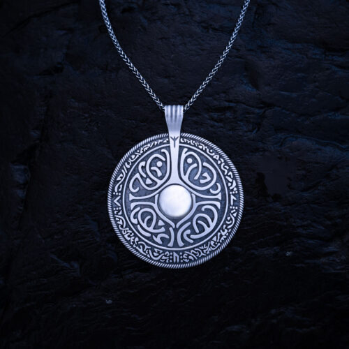 Sterling silver shield pendant with engraved Nordic runes on a silver chain against a dark background