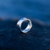 Handcrafted sterling silver water ring with flowing organic curves inspired by waves.