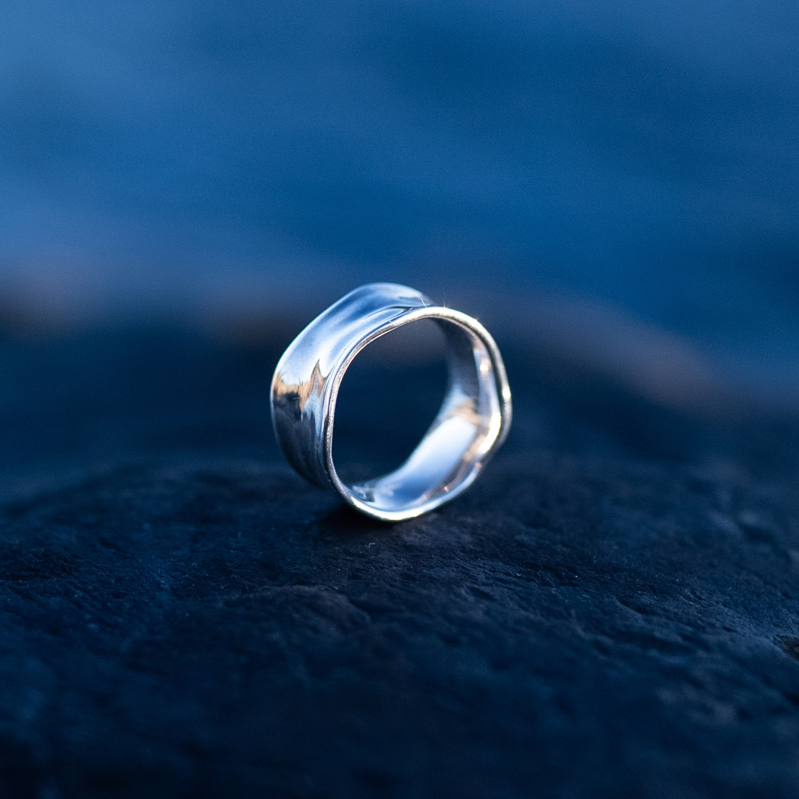 Handcrafted sterling silver water ring with flowing organic curves inspired by waves.
