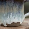 Close up shot of the handmade ceramic mug, “Singing Ice” by Jonna Jinton, featuring an ice-inspired glaze and textured surface inspired by Nordic winter landscapes.